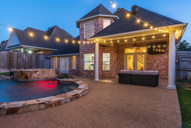 back of property featuring a pool with hot tub, a patio, and french doors