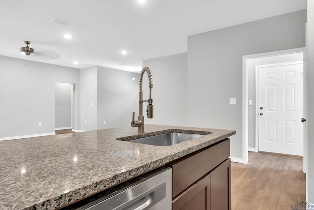 kitchen featuring sink, stainless steel dishwasher, ceiling fan, light wood-type flooring, and stone countertops