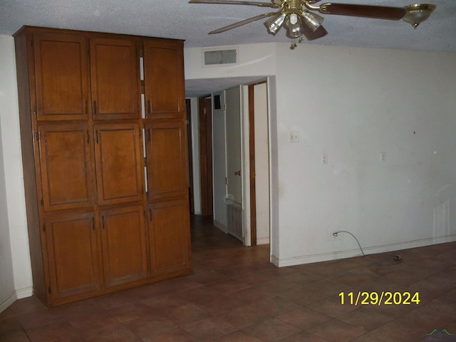 interior space with ceiling fan and a textured ceiling