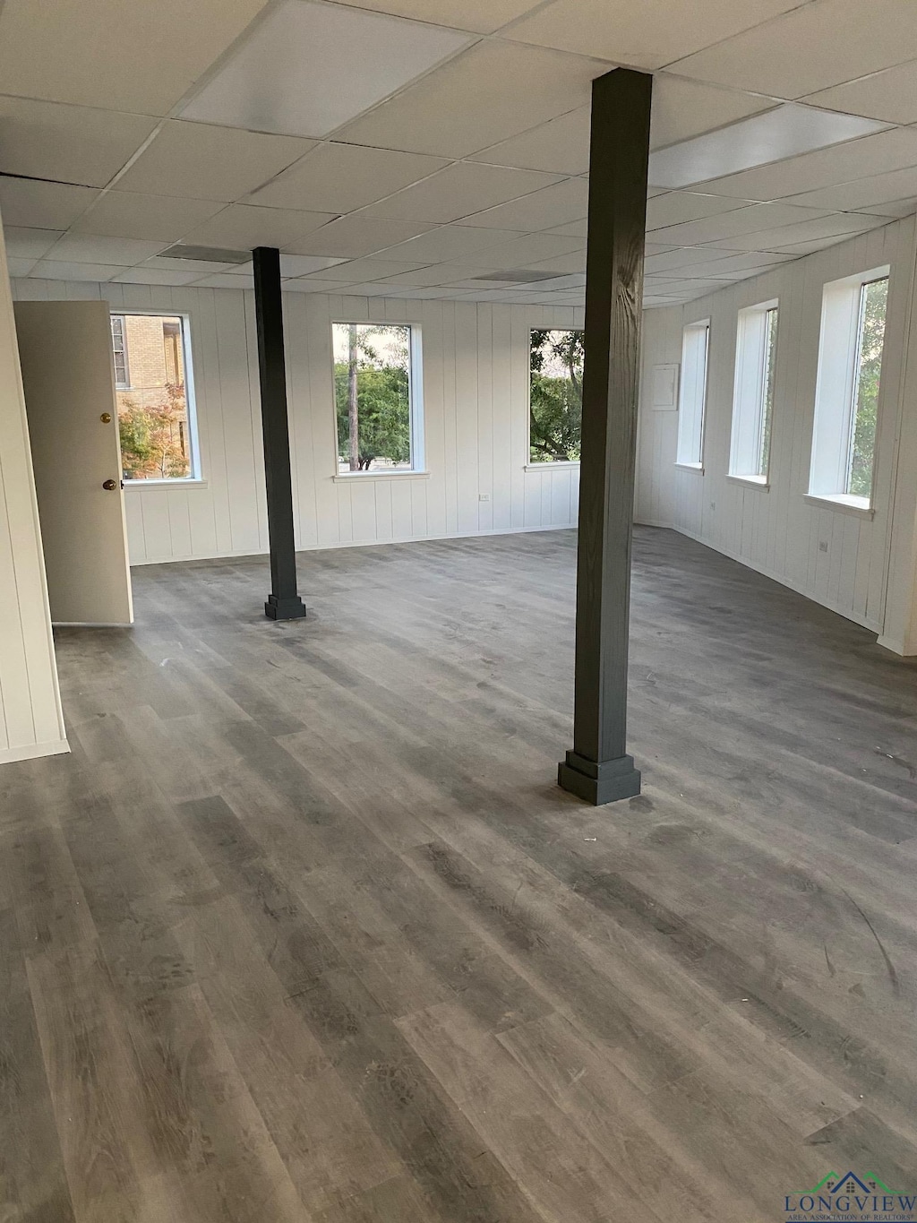 basement with a paneled ceiling and dark hardwood / wood-style flooring