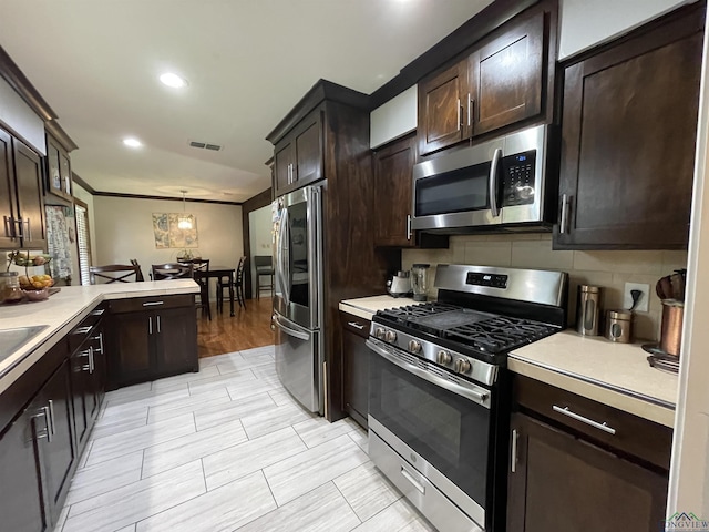 209 Lake Lamond Rd, Longview, TX 75604 - kitchen featuring appliances with stainless steel finishes, light countertops, dark brown cabinets, a peninsula, and recessed lighting