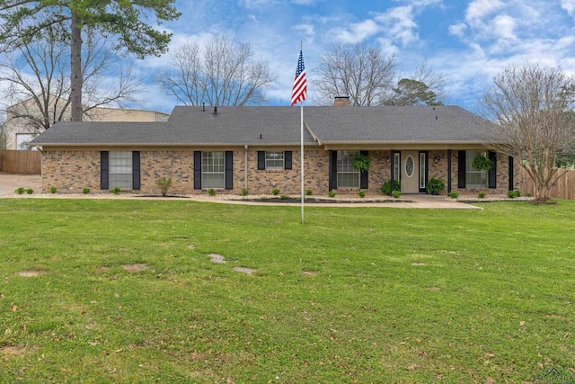 ranch-style home featuring brick siding, fence, a chimney, and a front lawn