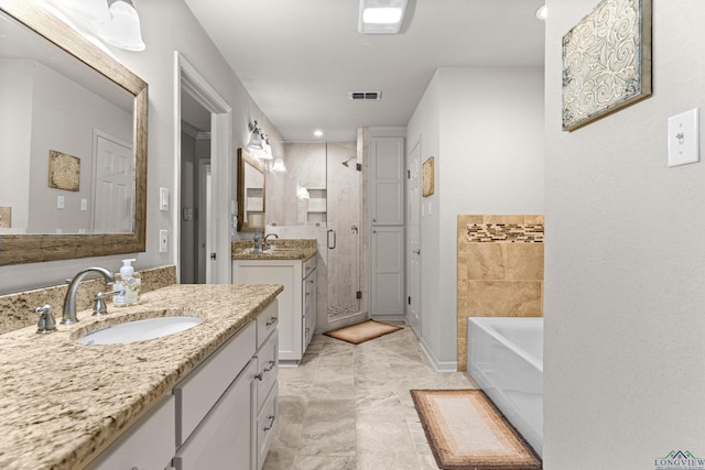 8 Honeysuckle Ln, Longview, TX 75605 - bathroom featuring a bath, a stall shower, two vanities, and recessed lighting