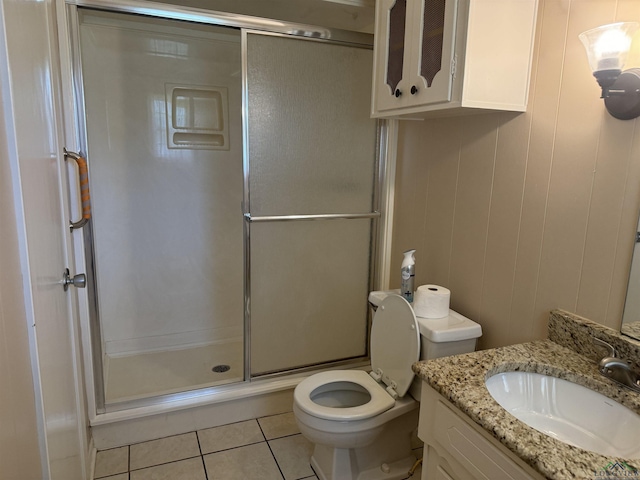 bathroom with vanity, tile patterned flooring, a stall shower, and toilet