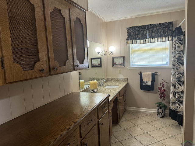 bathroom with crown molding, curtained shower, tile patterned floors, baseboards, and vanity