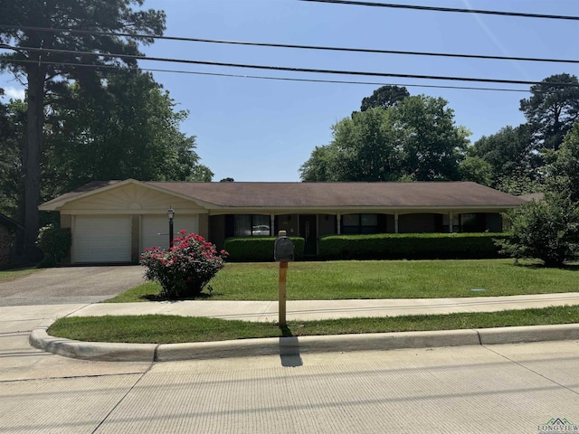 ranch-style house with a garage, aphalt driveway, and a front yard