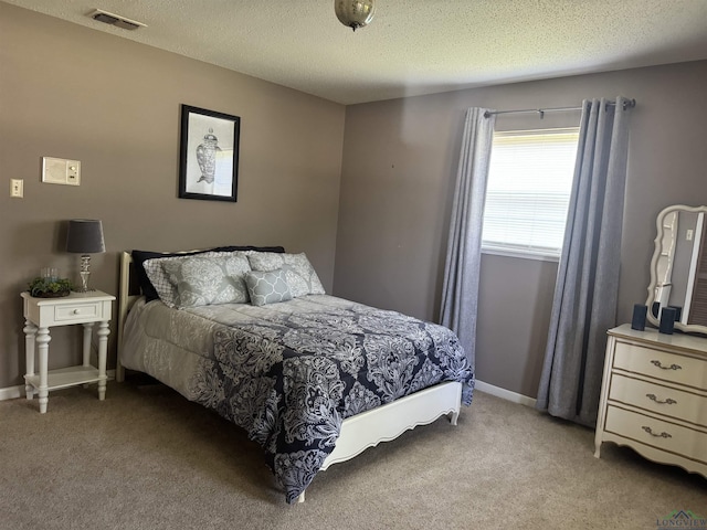 carpeted bedroom featuring baseboards, a textured ceiling, and visible vents