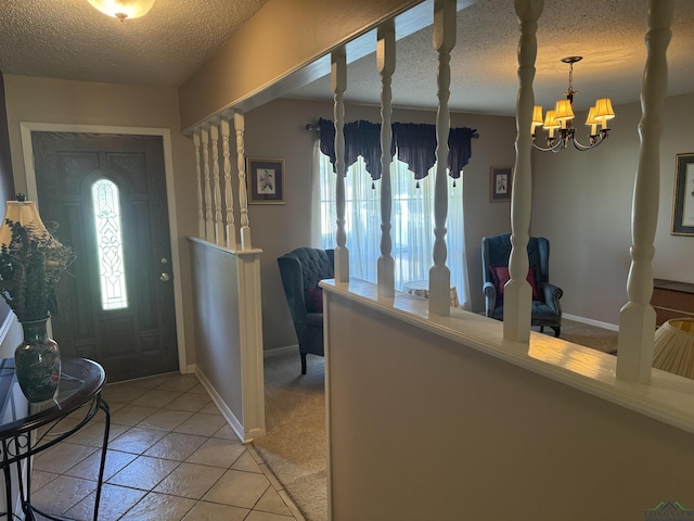 foyer with baseboards, a textured ceiling, light tile patterned floors, and a notable chandelier