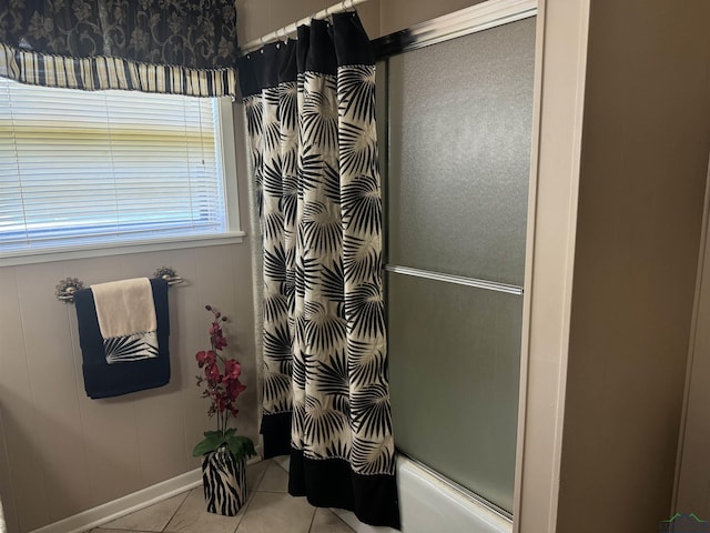 bathroom with shower / bath combination with glass door and tile patterned floors