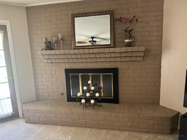 room details with crown molding, carpet, a ceiling fan, and a brick fireplace