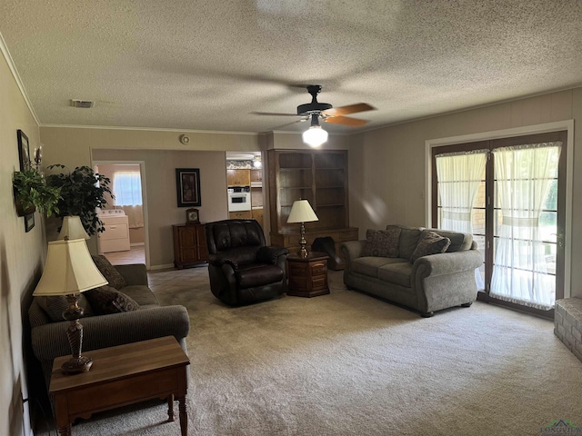 living area with carpet flooring, a textured ceiling, ceiling fan, and crown molding
