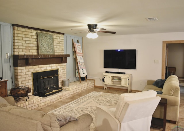 living area with baseboards, visible vents, and ceiling fan