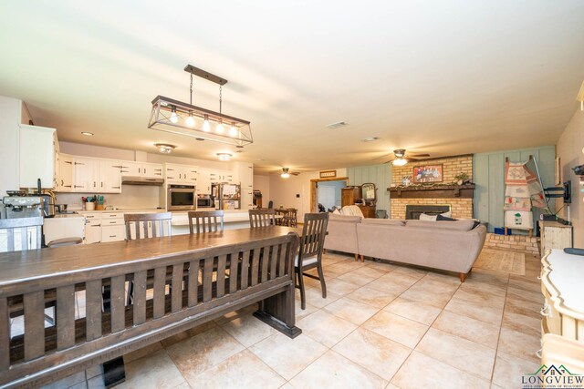 12545 Fm 968 W, Longview, TX 75602 - dining area with ceiling fan, light tile patterned floors, and a brick fireplace