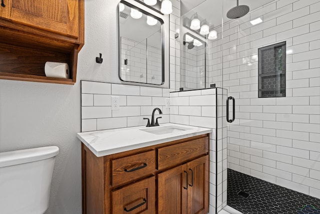 full bath featuring tasteful backsplash, a stall shower, toilet, and vanity