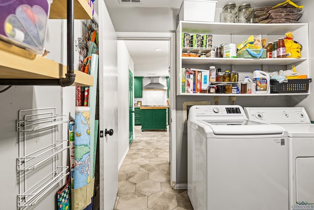 washroom featuring laundry area, visible vents, washing machine and clothes dryer, and light tile patterned floors