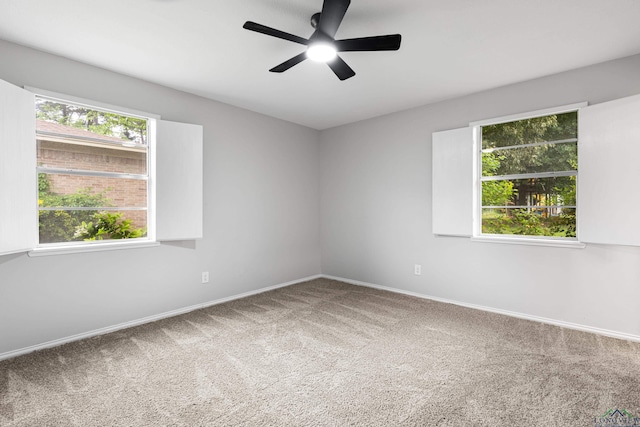 carpeted empty room featuring ceiling fan and baseboards
