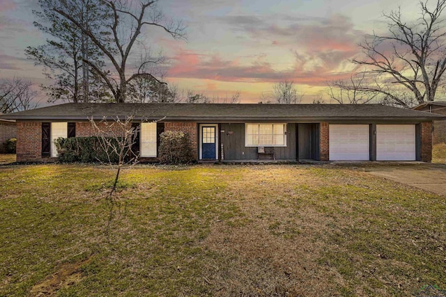 ranch-style home featuring brick siding, board and batten siding, a front lawn, concrete driveway, and a garage