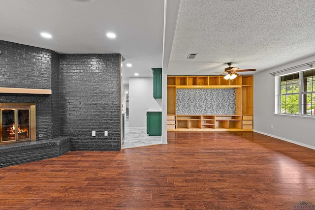 unfurnished living room featuring recessed lighting, a fireplace, ceiling fan, visible vents, and wood finished floors