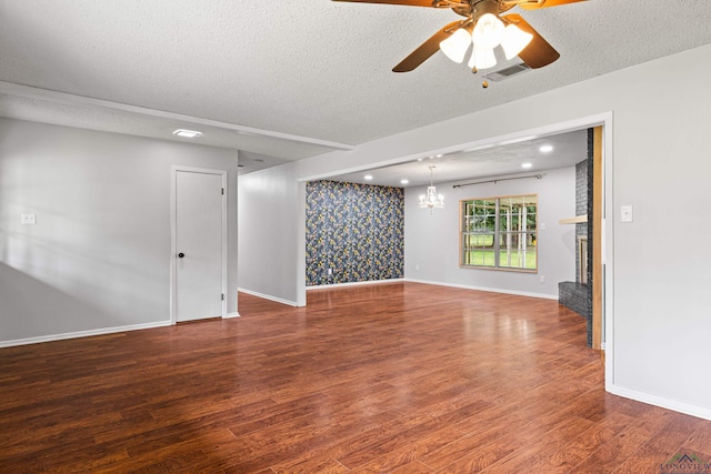 spare room with a textured ceiling, baseboards, wood finished floors, and ceiling fan with notable chandelier