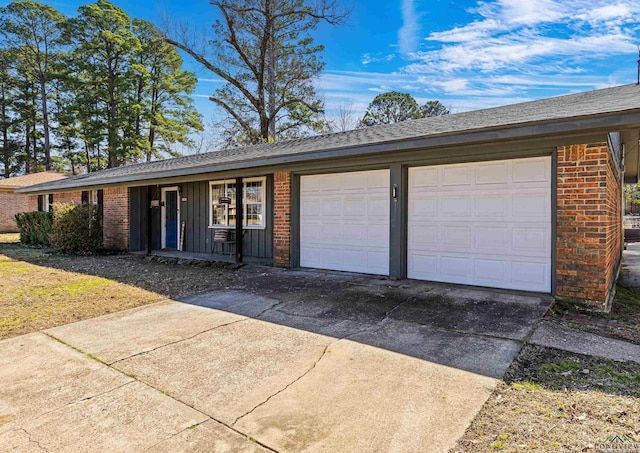 single story home with board and batten siding, concrete driveway, brick siding, and an attached garage