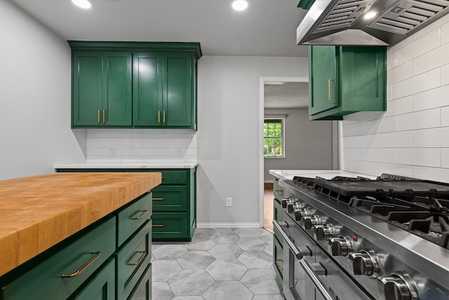 kitchen featuring gas range oven, custom exhaust hood, decorative backsplash, and green cabinets