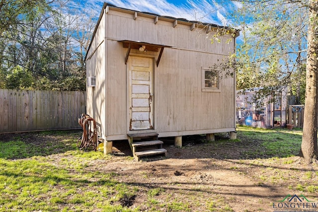 view of outdoor structure featuring an outdoor structure, entry steps, and fence