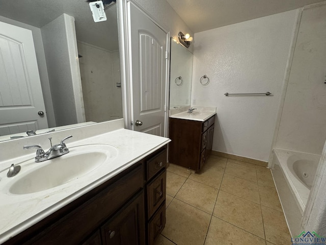 bathroom featuring tile patterned flooring, vanity, and a tub to relax in