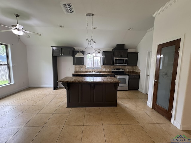 kitchen with decorative backsplash, stainless steel appliances, vaulted ceiling, sink, and light tile patterned floors