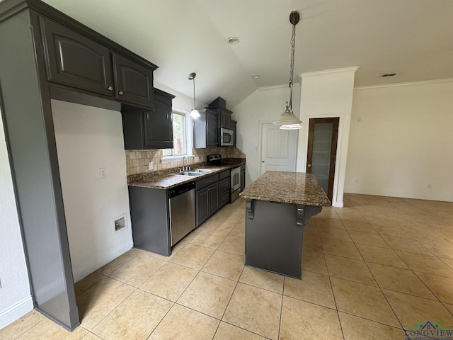 kitchen featuring stainless steel appliances, a kitchen island, backsplash, lofted ceiling, and light tile patterned floors