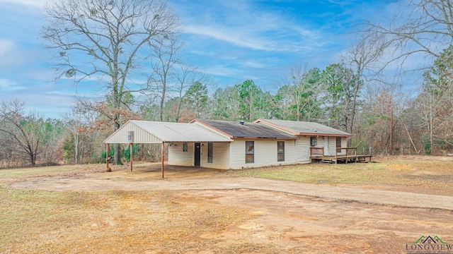 ranch-style house with a wooden deck, a front yard, and a carport