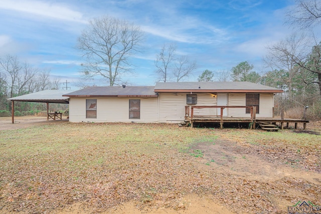 rear view of property featuring a wooden deck and a yard