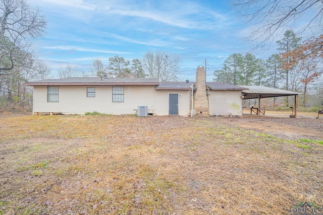 back of house with central AC and a carport