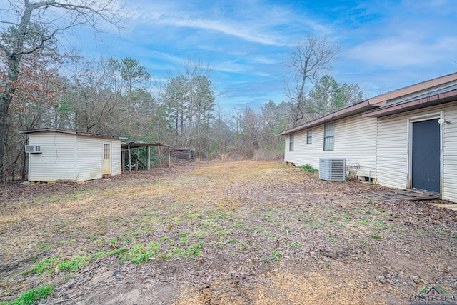 view of yard with cooling unit and a storage shed