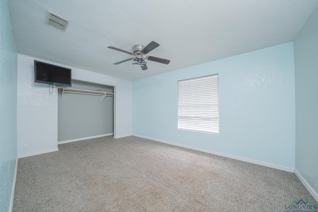 unfurnished bedroom featuring ceiling fan, carpet flooring, a closet, and a textured ceiling