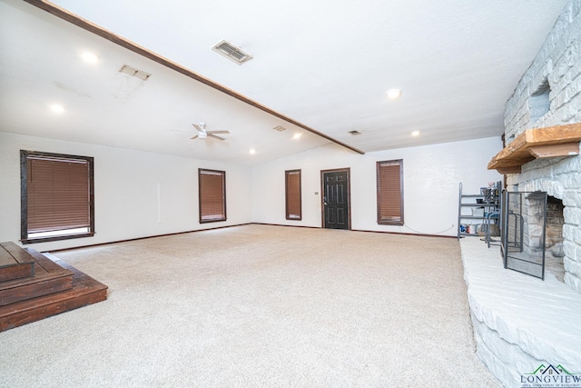 carpeted living room featuring vaulted ceiling, ceiling fan, and a fireplace