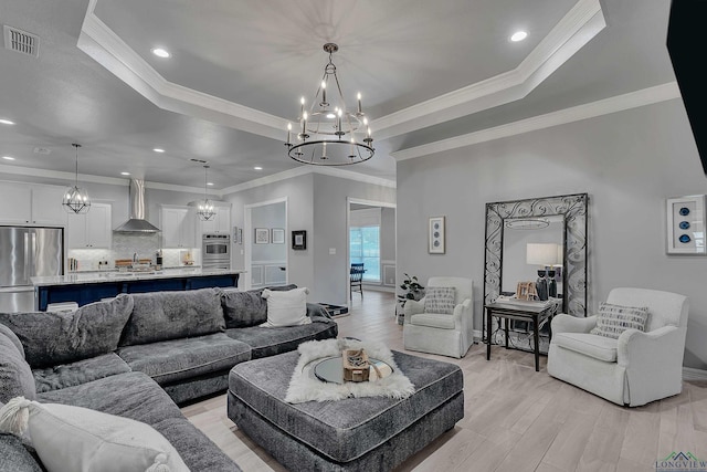 living room with a raised ceiling, crown molding, and sink