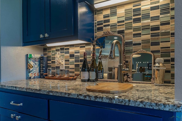 kitchen featuring sink, blue cabinets, and backsplash