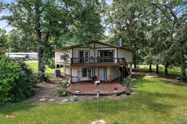 rear view of house with a deck, a yard, and central air condition unit