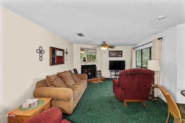 living room featuring ceiling fan, carpet, and a textured ceiling