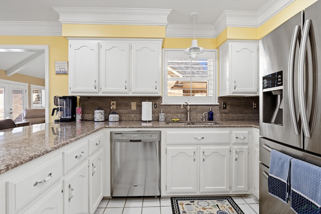 kitchen with stainless steel appliances, light tile patterned flooring, sink, and white cabinetry