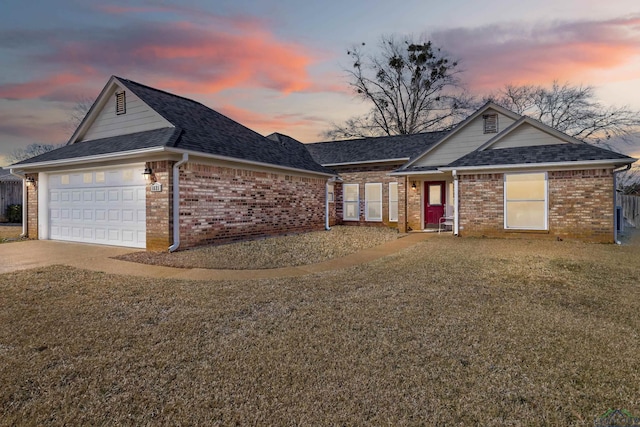 single story home with a garage and a lawn