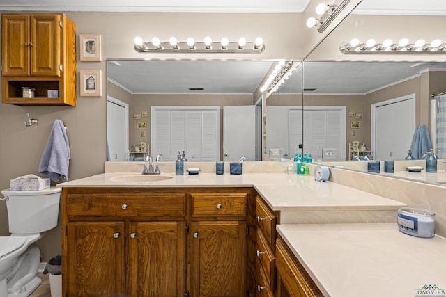 bathroom with vanity, ornamental molding, and toilet