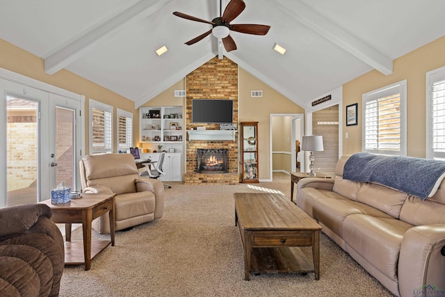 living room with ceiling fan, vaulted ceiling with beams, a fireplace, built in shelves, and light colored carpet