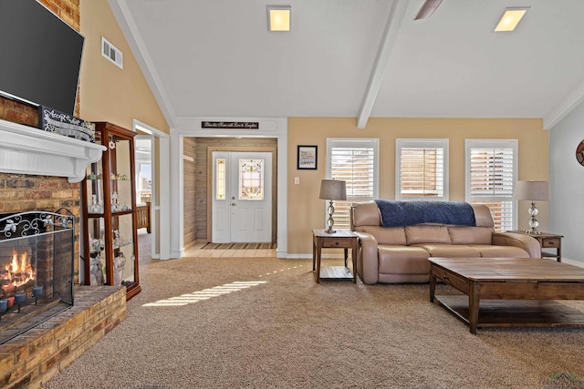 carpeted living room with a healthy amount of sunlight, a brick fireplace, and vaulted ceiling with beams