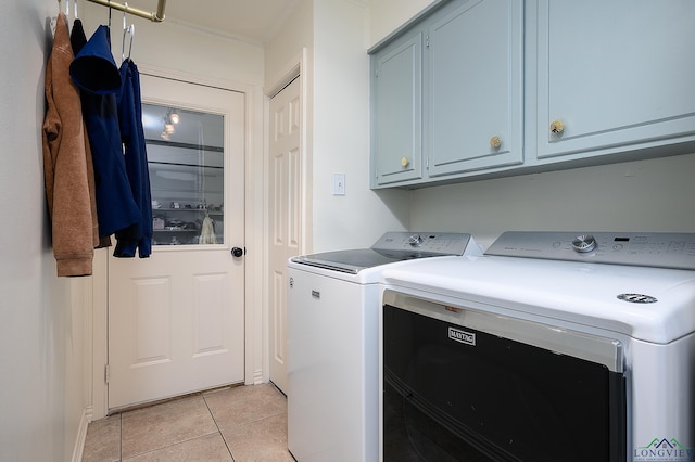 laundry room featuring cabinet space, washer and clothes dryer, and light tile patterned floors