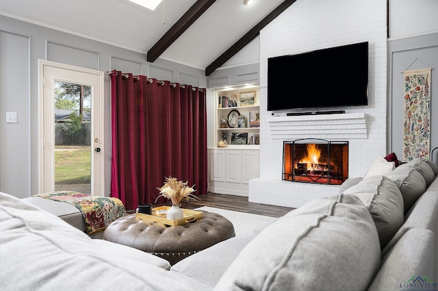 living room featuring lofted ceiling with beams, a fireplace, a decorative wall, and wood finished floors