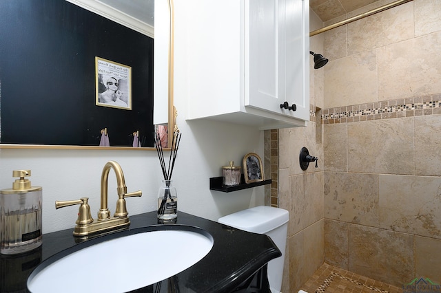 bathroom featuring tiled shower, a sink, and toilet