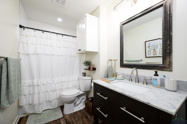 full bath with visible vents, vanity, toilet, and wood finished floors