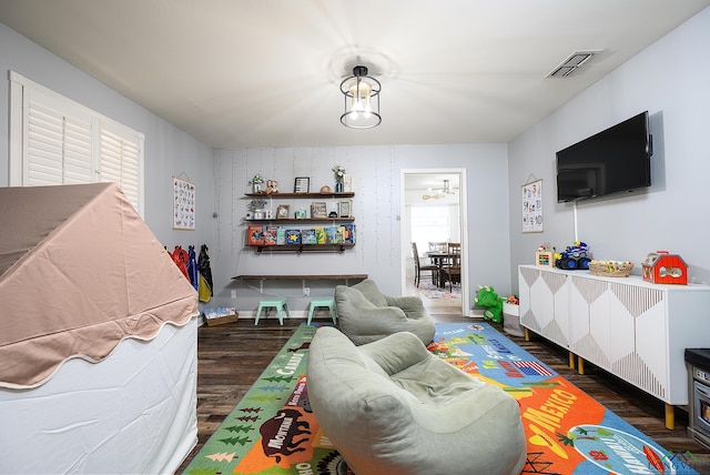 living room with visible vents, baseboards, and wood finished floors