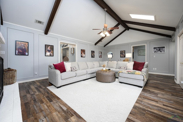 living area featuring dark wood finished floors, visible vents, a decorative wall, lofted ceiling with beams, and ceiling fan